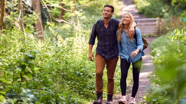 Erwachsene Personen machen einen kurzen Spaziergang im Park zur Entlastung bei Ischiasbeschwerden