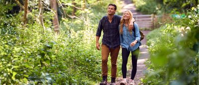 Erwachsene Personen machen einen kurzen Spaziergang im Park zur Entlastung bei Ischiasbeschwerden