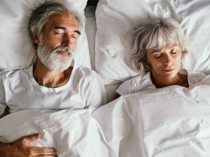 Älteres Paar liegt schlafend im Bett