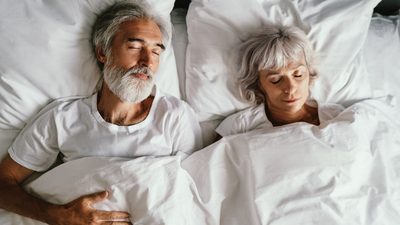 Älteres Paar liegt schlafend im Bett