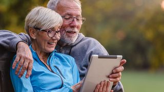 Seniorenpaar mit Tablet im Park – informiert sich über Herzgesundheit im Alter