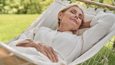 Frau entspannt in einer Hängematte im Garten – Ruhe und Stressreduktion bei Tinnitus und Schwindel