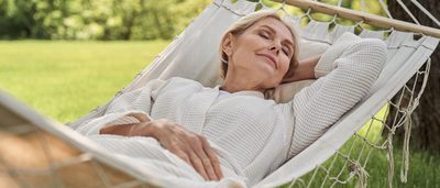 Frau entspannt in einer Hängematte im Garten – Ruhe und Stressreduktion bei Tinnitus und Schwindel