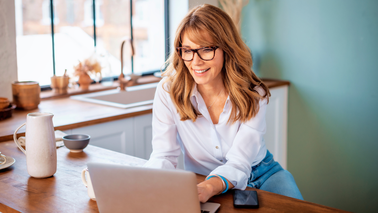 Frau arbeitet am Laptop im Homeoffice – mögliche Haltungsfehler durch Bildschirmarbeit