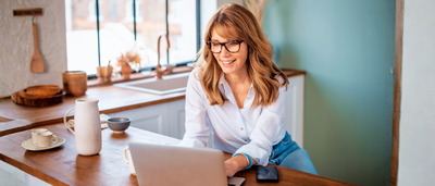 Frau arbeitet am Laptop im Homeoffice – mögliche Haltungsfehler durch Bildschirmarbeit