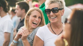 Zwei Frauen in Menschenmengen – ohne Schwindel auf dem Konzert.