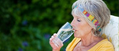 Ältere Frau beim Trinken von Wasser zur Unterstützung der Nierenfunktion im Alter