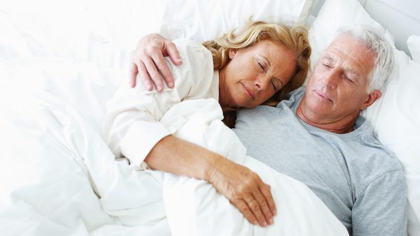 Älteres Paar liegt schlafend im Bett