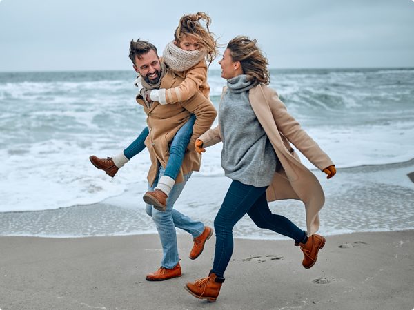Familie mit Kind spaziert am Strand