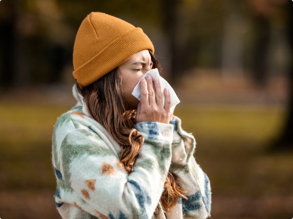 Junge Frau putzt sich die Nase