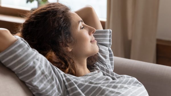 Frau liegt zufrieden im Sessel - Symbol für ausgeglichenen Hormonhaushalt