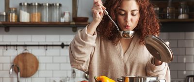 Frau kocht eine Hühnersuppe gegen Erkältung.
