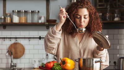 Frau kocht eine Hühnersuppe gegen Erkältung.