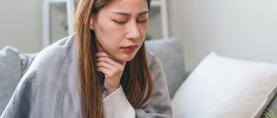 Frau hat eine Erkältung mit Halsschmerzen.