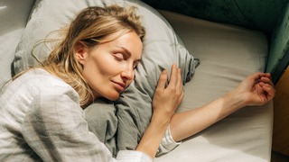 Frau liegt im Bett und schläft.