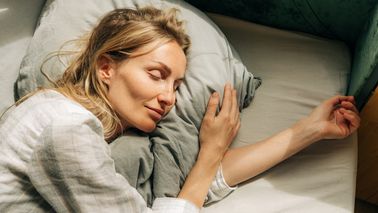 Frau liegt im Bett und schläft.