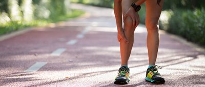 Frau hat Knieschmerzen nach dem Joggen