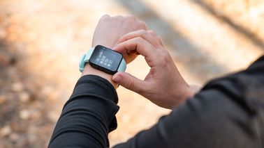 Mann guckt auf seinen Fitnesstracker