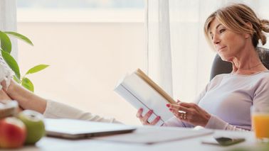 Frau macht Digital Detox und liest ein Buch.