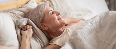 Ältere Frau liegt entspannt und erleichtert in Ihrem Bett