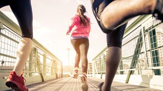 Menschen joggen über eine Brücke in der Stadt