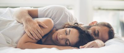 Paar liegt entspannt im Bett und schläft