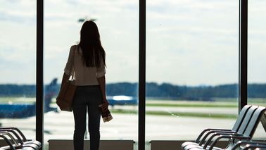 Frau mit Flugangst am Gate eines Flughafens.