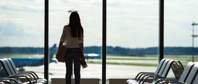 Frau mit Flugangst am Gate eines Flughafens.