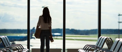 Frau mit Flugangst am Gate eines Flughafens.