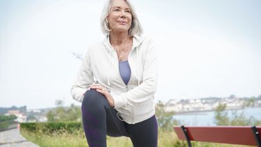 Ältere Frau dehnt sich nach dem Lauftraining