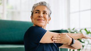 Ältere Frau macht eine Schulterübung