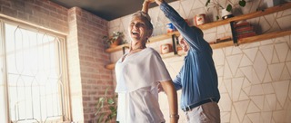 Mann und Frau tanzen in einer Wohnung.