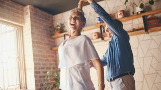 Mann und Frau tanzen in einer Wohnung.
