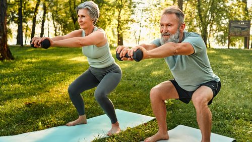 Älteres Paar macht Krafttraining im Garten