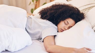 Frau liegt im Bett und schläft