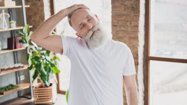 Älterer Mann stretcht seinen verspannten Nacken.