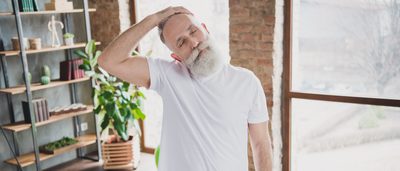 Älterer Mann stretcht seinen verspannten Nacken.