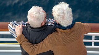 Älteres Paar schaut von einem Schiff aus aufs Meer