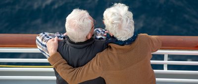 Älteres Paar schaut von einem Schiff aus aufs Meer