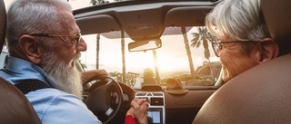 Älteres Pärchen fährt mit dem Auto in den Urlaub.