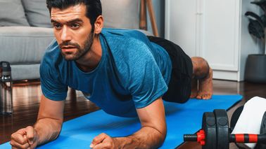 Mann macht eine Plank auf einer Fitnessmatte. Krafttraining ohne Geräte zum Muskelaufbau