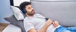 Mann hört enspannende Frequenzen zum Einschlafen