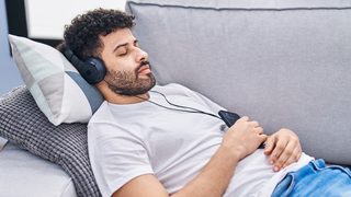 Mann hört enspannende Frequenzen zum Einschlafen