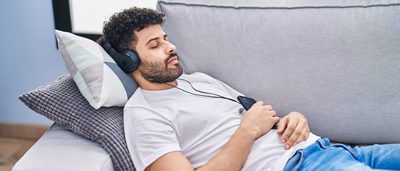 Mann hört enspannende Frequenzen zum Einschlafen