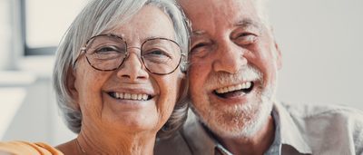 Älterer Mann und ältere Frau lachen in die Kamera.