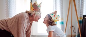 Lächelnde Großmutter und Enkelin mit selbstgebastelten Kronen.
