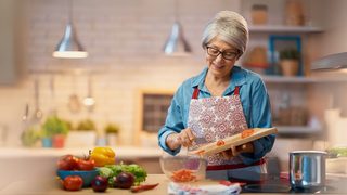 Frau kocht mit frischen Zutaten in der Küche – bekömmliche Ernährung bei Magenentzündung
