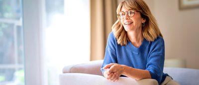 Eine fröhliche Frau mittleren Alters sitzt auf einem Sessel