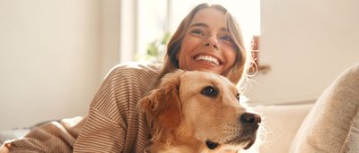 Glückliche Frau kuschelt mit ihrem Hund – Tiertherapie zur Entspannung und Stressreduktion