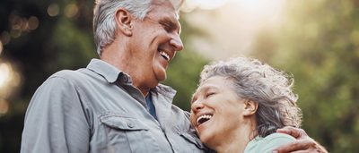 Ein Paar über 60 Jahre lacht zufrieden und umarmt sich